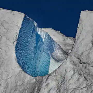 Natural arch carved into an ice cliff in Greenland