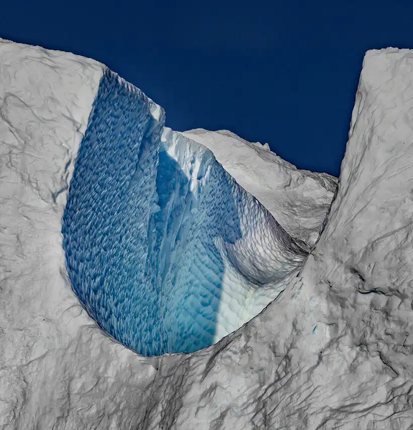 Natural arch carved into an ice cliff in Greenland