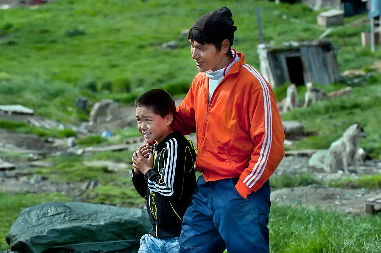Grand frère et petit frère souriants marchant ensemble dans les rues de Sisimiut au Groenland