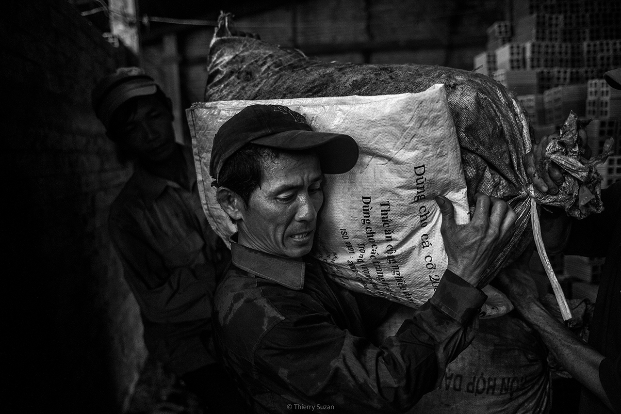Vietnamese worker processing copra in a traditional workshop in the Mekong Delta, Vietnam.