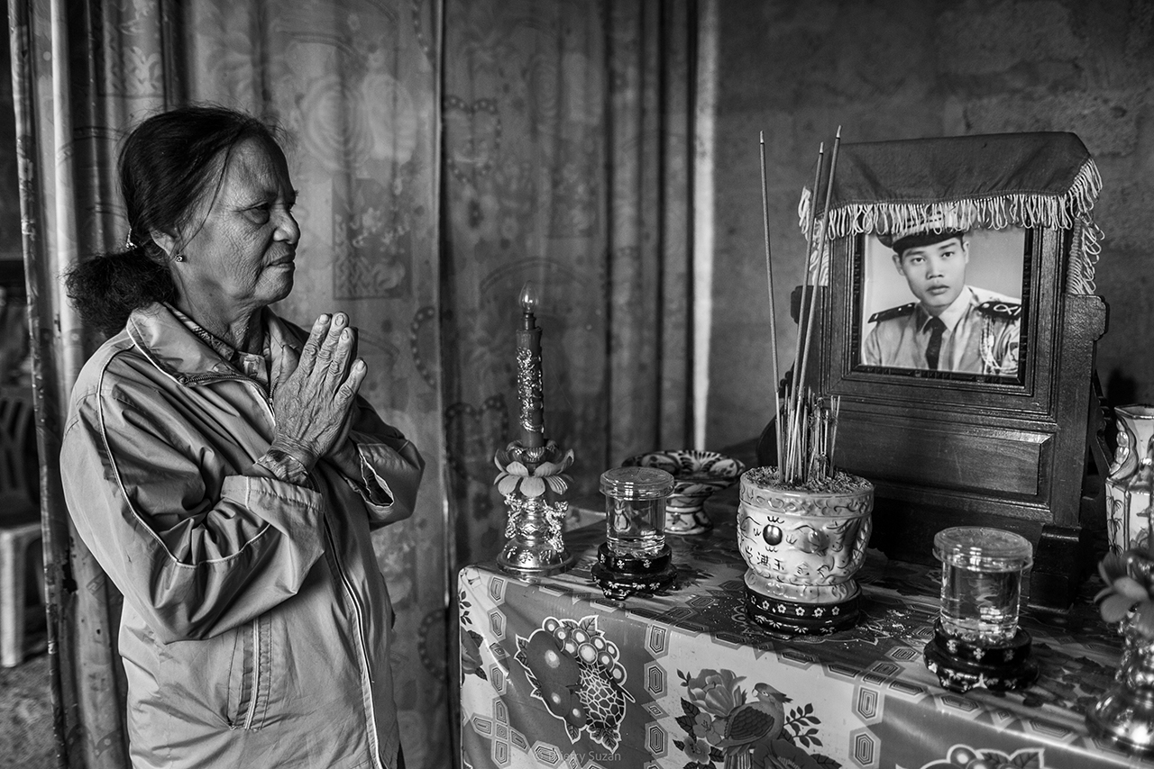 Vietnamese woman practicing ancestor worship at home in Đắk Tô, capturing an intimate moment of local tradition.